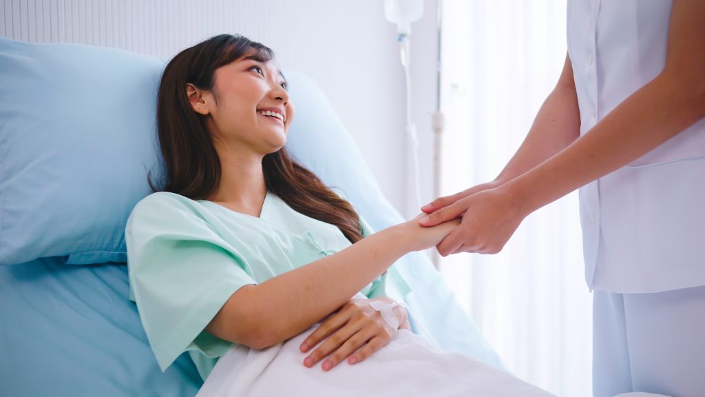 Nurse is talking and giving encouragement to the patient after surgery.
